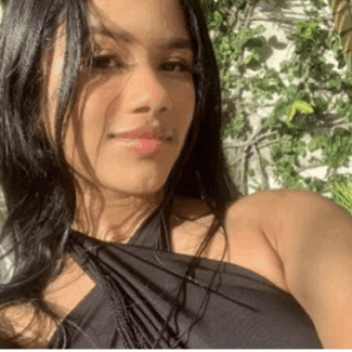 Massiel Rodriguez Famania smiling at the camera from a tropical background.